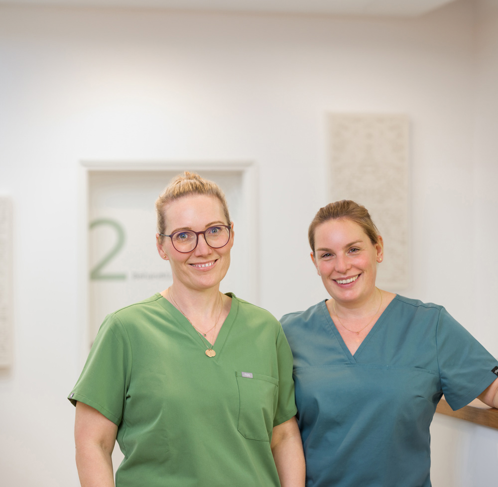 Beide Ärztinnen lächeln in die Kamera